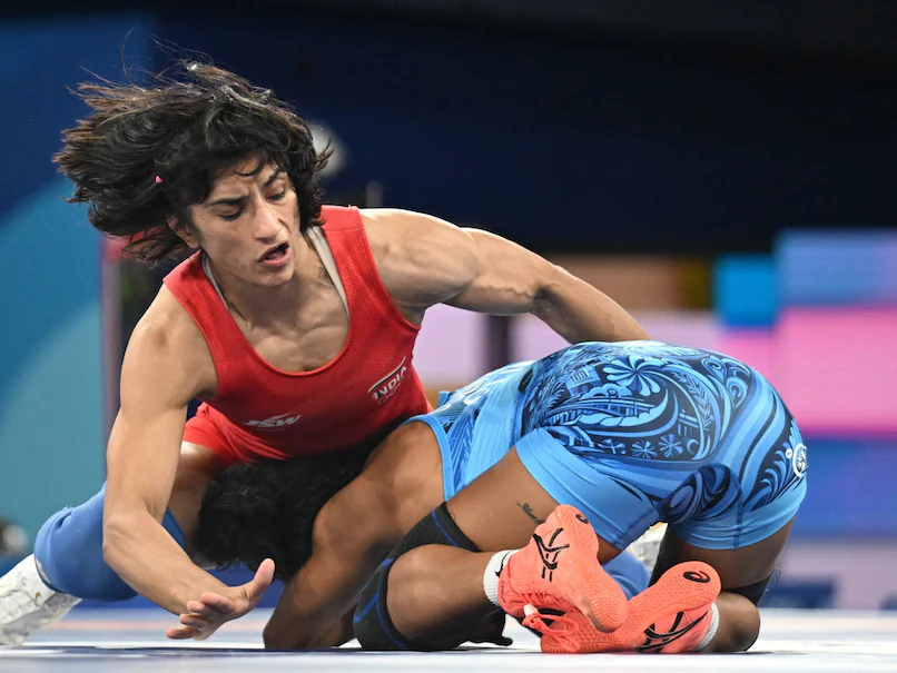 Vinesh Phogat in action during a wrestling match , demonstrating her powerful techniques and agility in the ring , indian wrestling champion Vinesh Phogat during a press conference, addressing the media with determination and focus. 