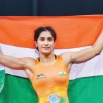 Vinesh Phogat, an Indian athlete, holding the national flag at the Paris Olympics , Indian woman wrestler Vinesh Phogat, wearing traditional wrestling attire, standing confidently in a wrestling ring, symbolizing strength and resilience